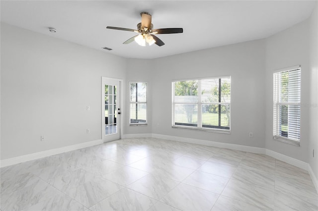 spare room with a wealth of natural light and ceiling fan