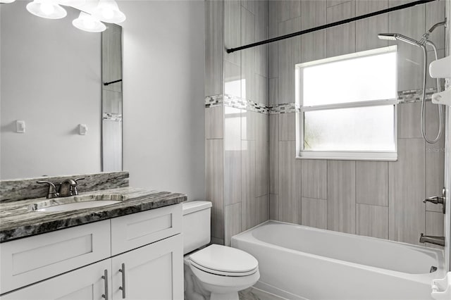 full bathroom featuring vanity, tiled shower / bath, and toilet