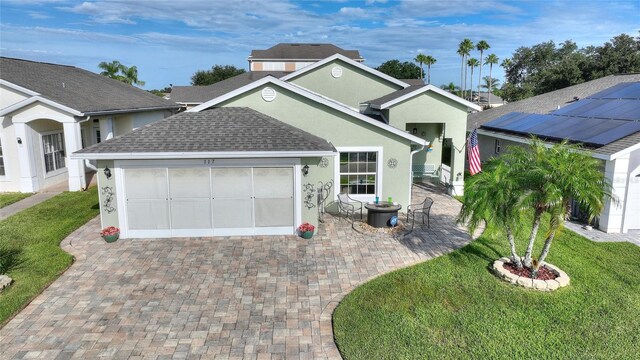 view of front of house featuring solar panels, a garage, and a front lawn