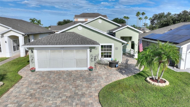 view of front of house featuring a garage, roof with shingles, decorative driveway, a front lawn, and stucco siding