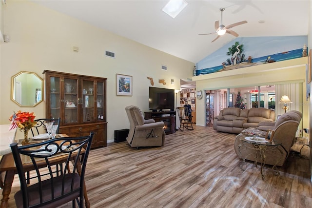 living room with high vaulted ceiling, wood finished floors, visible vents, and a ceiling fan