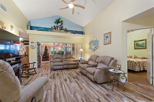 living area featuring high vaulted ceiling, ceiling fan, visible vents, and wood finished floors