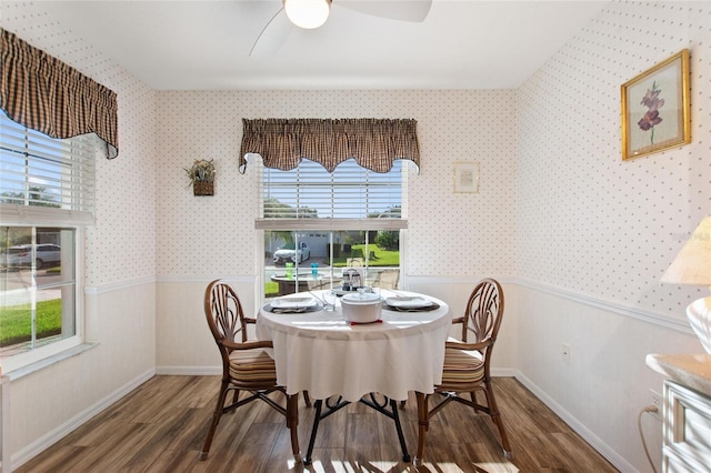 dining space with wallpapered walls, a ceiling fan, baseboards, and dark wood-style flooring