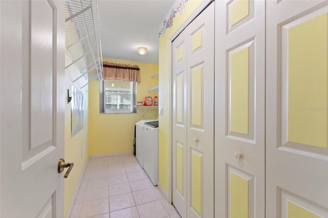 interior space with light tile patterned flooring, washer and clothes dryer, and baseboards