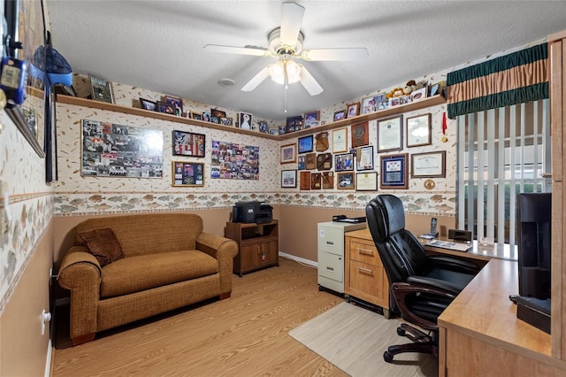 office space featuring a textured ceiling, a ceiling fan, and wallpapered walls