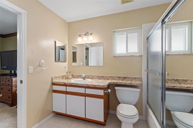 full bathroom featuring bath / shower combo with glass door, toilet, vanity, baseboards, and tile patterned floors