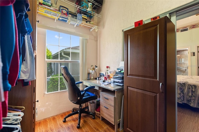 office with a textured wall and light wood-style flooring