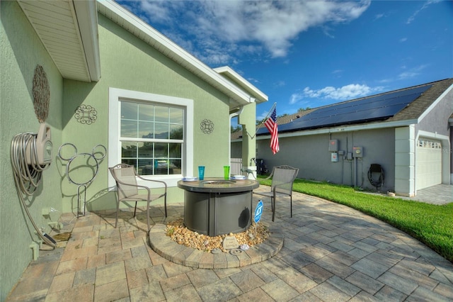 view of patio featuring a garage and a fire pit