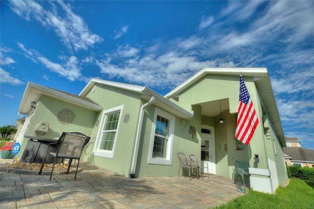 back of property with a patio area and stucco siding