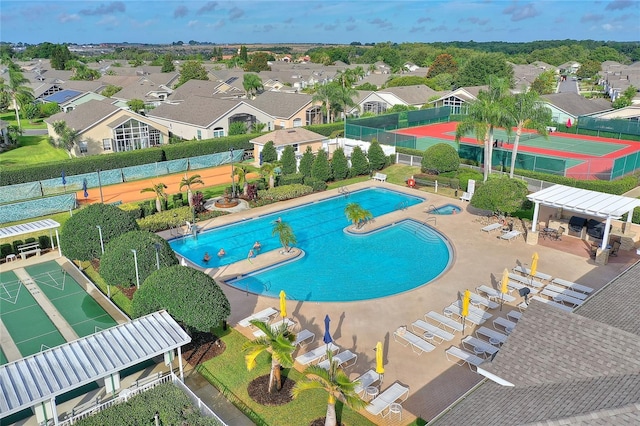 pool featuring shuffleboard, a patio, fence, and a residential view