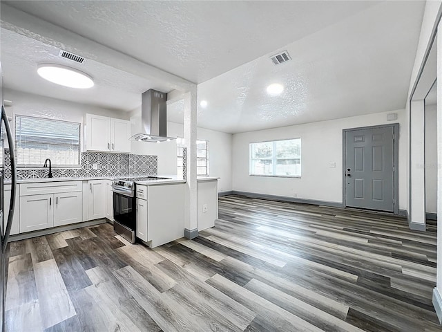 kitchen with light countertops, electric range, island exhaust hood, and white cabinets