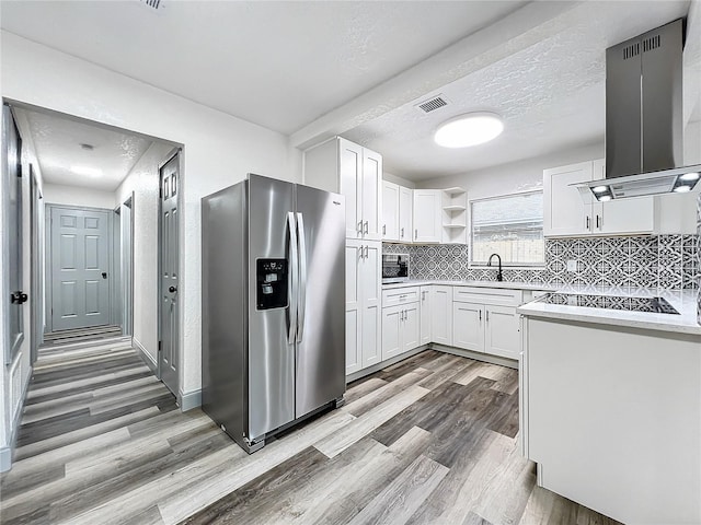 kitchen with visible vents, white cabinetry, light countertops, open shelves, and stainless steel fridge