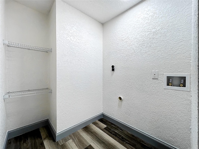 laundry room featuring a textured wall, laundry area, washer hookup, wood finished floors, and baseboards