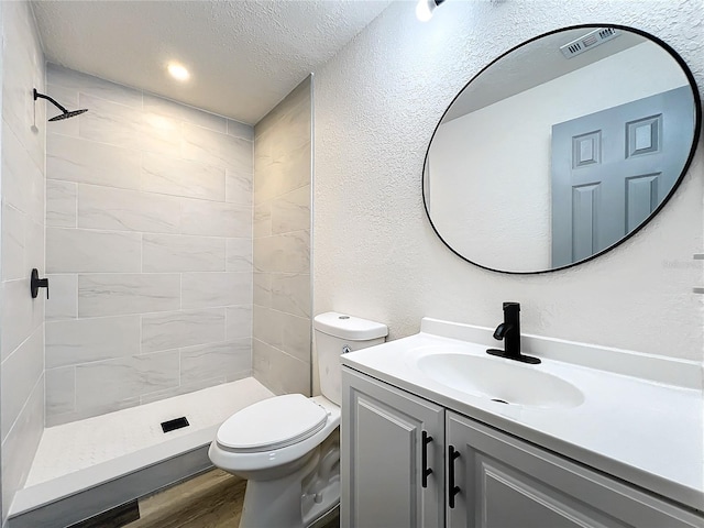 full bathroom featuring toilet, a stall shower, wood finished floors, and vanity