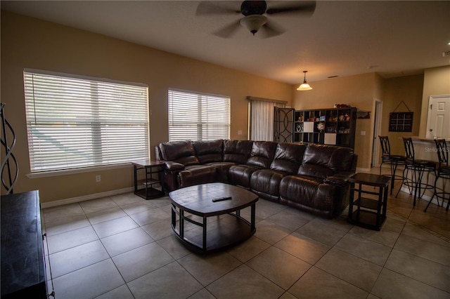 living room featuring ceiling fan and dark tile patterned floors