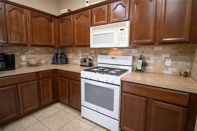 kitchen featuring white appliances, light tile patterned floors, and tasteful backsplash