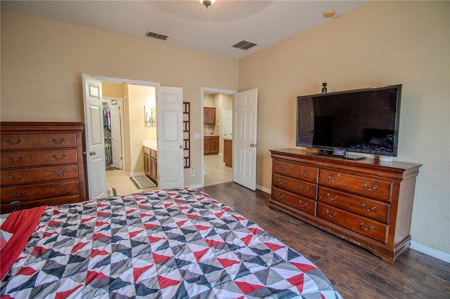 bedroom with connected bathroom and dark hardwood / wood-style floors