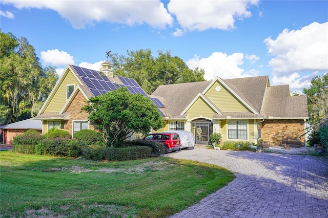 view of front facade featuring solar panels and a front yard