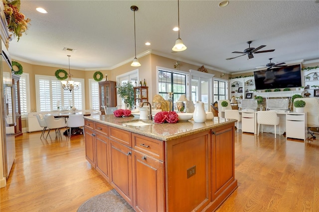 kitchen with light wood finished floors, a textured ceiling, and a sink