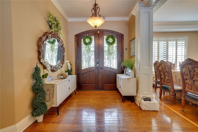 entryway featuring arched walkways, light wood-style flooring, ornamental molding, french doors, and ornate columns