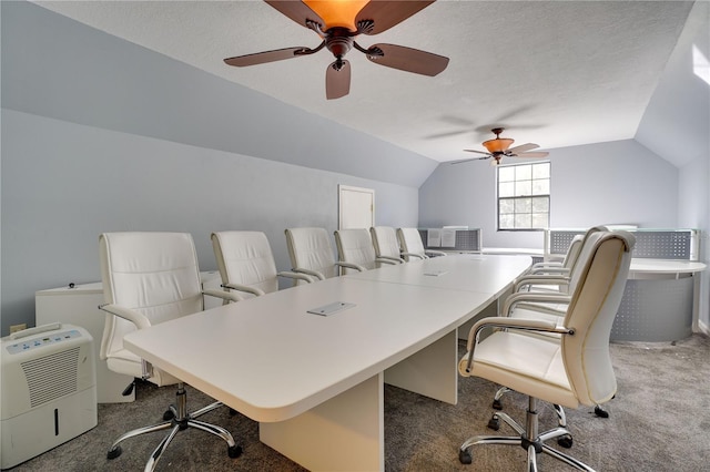 home office featuring lofted ceiling, a ceiling fan, a textured ceiling, and carpet flooring