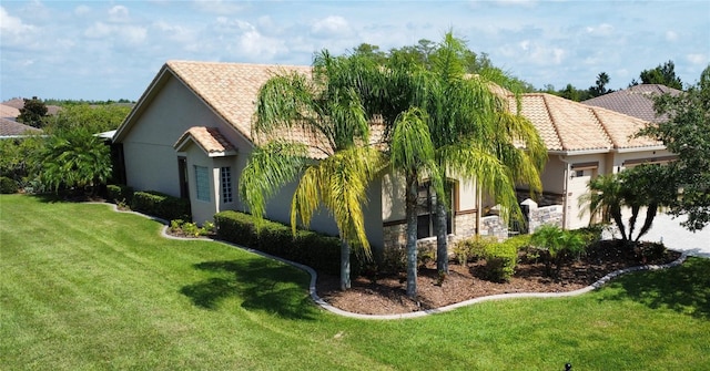 view of property exterior featuring stone siding, a lawn, an attached garage, and stucco siding