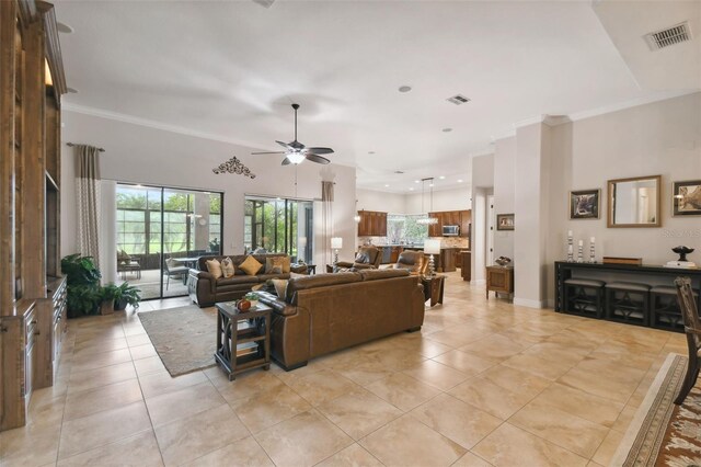 tiled living room with ceiling fan and crown molding