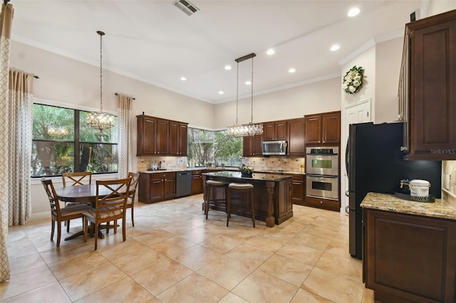 kitchen featuring a kitchen breakfast bar, pendant lighting, tasteful backsplash, a center island, and stainless steel appliances