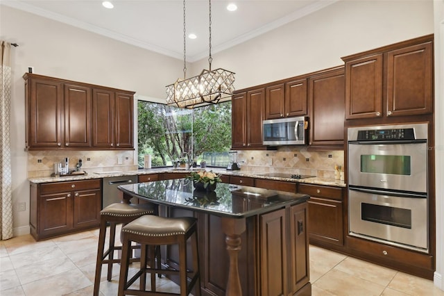 kitchen featuring decorative backsplash, pendant lighting, appliances with stainless steel finishes, a center island, and light tile patterned flooring