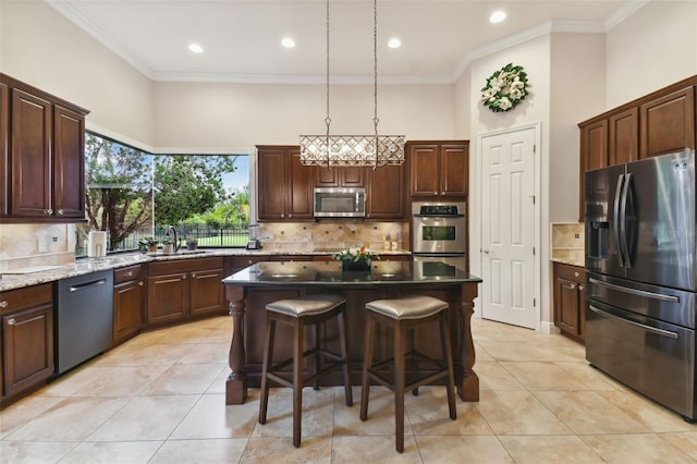 kitchen featuring sink, backsplash, appliances with stainless steel finishes, and a kitchen island