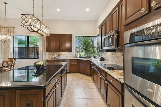 kitchen with light tile patterned floors, backsplash, light stone counters, and stainless steel appliances