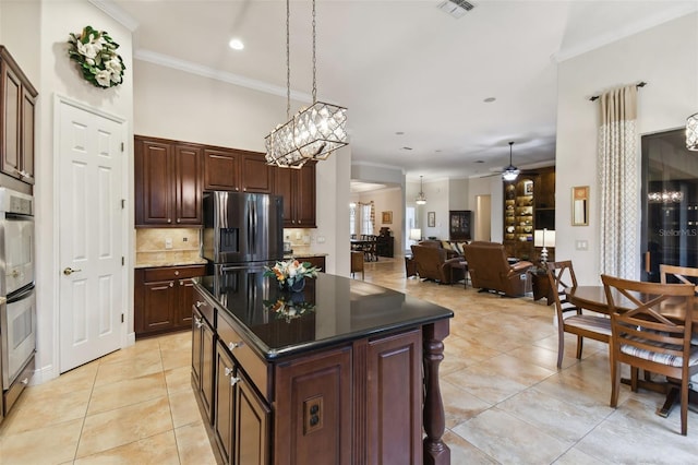 kitchen featuring decorative backsplash, stainless steel refrigerator with ice dispenser, ceiling fan with notable chandelier, light tile patterned floors, and a center island