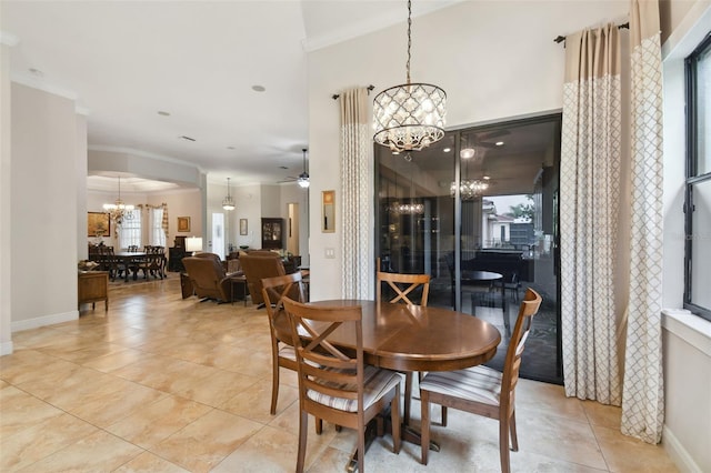 tiled dining area featuring ceiling fan with notable chandelier, a healthy amount of sunlight, and ornamental molding