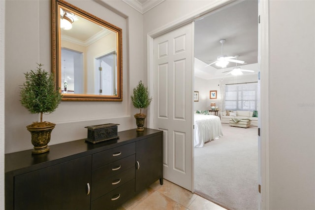 corridor with ornamental molding and light colored carpet