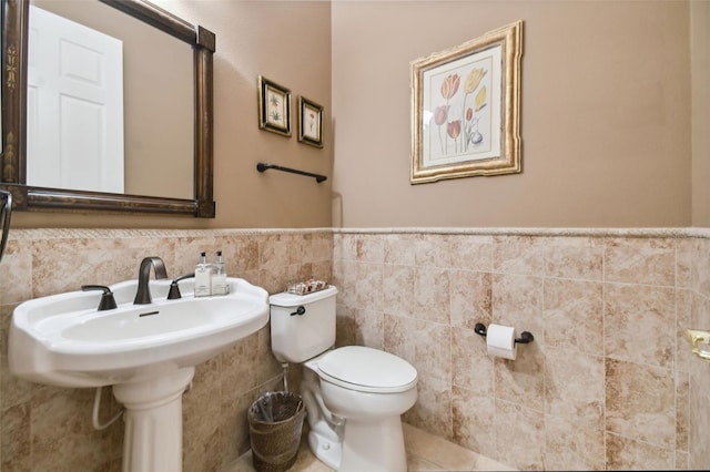 bathroom featuring tile patterned flooring, tile walls, and toilet