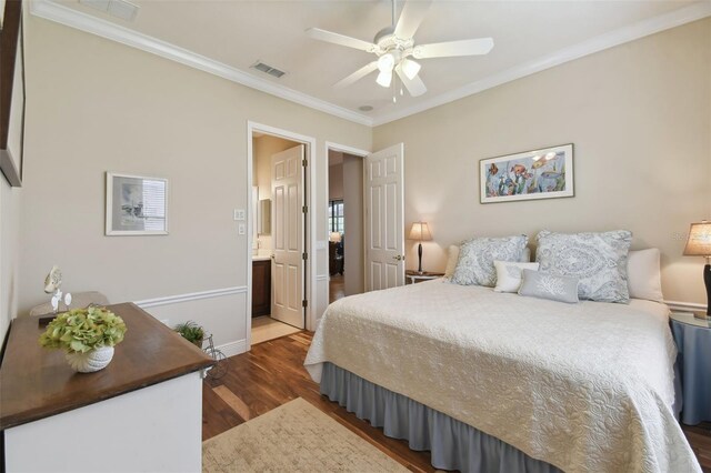 bedroom featuring ceiling fan, ornamental molding, ensuite bathroom, and wood-type flooring