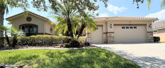 mediterranean / spanish-style home with a front yard and a garage