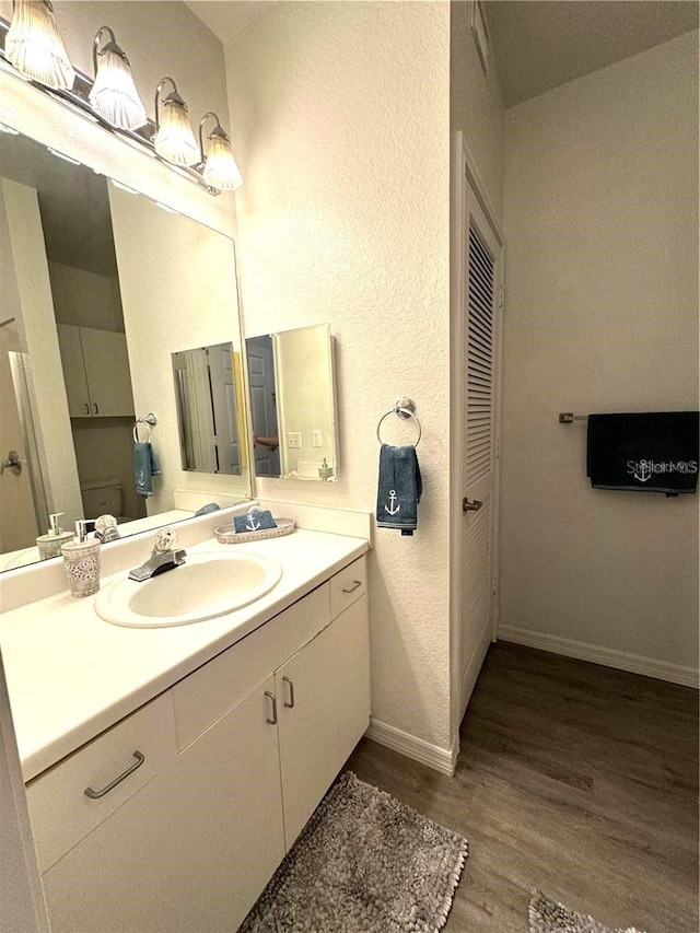 bathroom with hardwood / wood-style floors and vanity