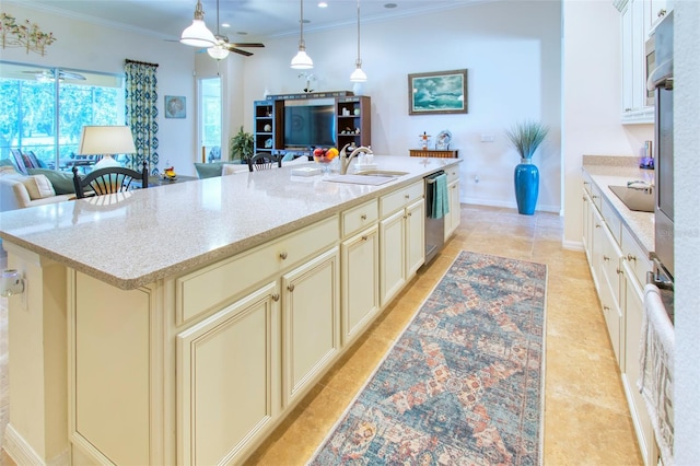 kitchen featuring light stone counters, an island with sink, sink, ceiling fan, and appliances with stainless steel finishes