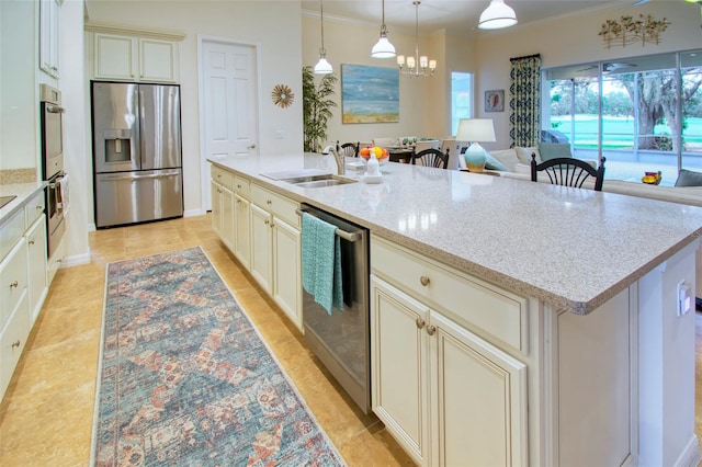 kitchen featuring decorative light fixtures, light stone counters, an island with sink, sink, and appliances with stainless steel finishes