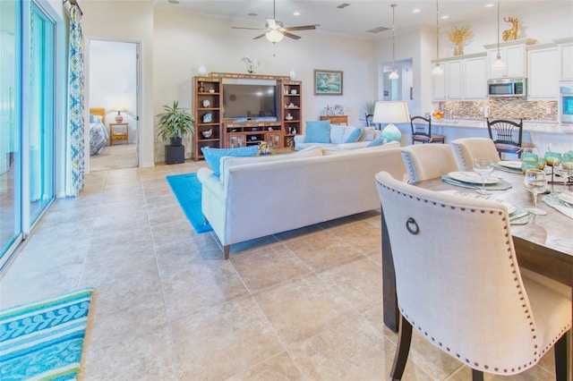 living room with ceiling fan and ornamental molding