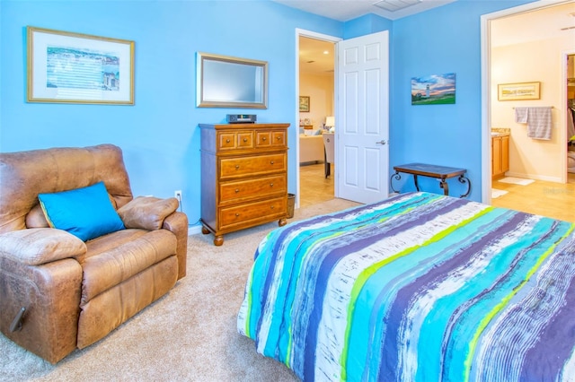 bedroom featuring ensuite bathroom and carpet flooring