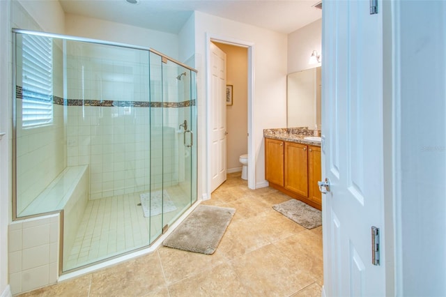 bathroom featuring tile patterned floors, walk in shower, toilet, and vanity