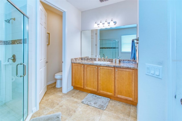 bathroom featuring vanity, toilet, an enclosed shower, and tile patterned floors