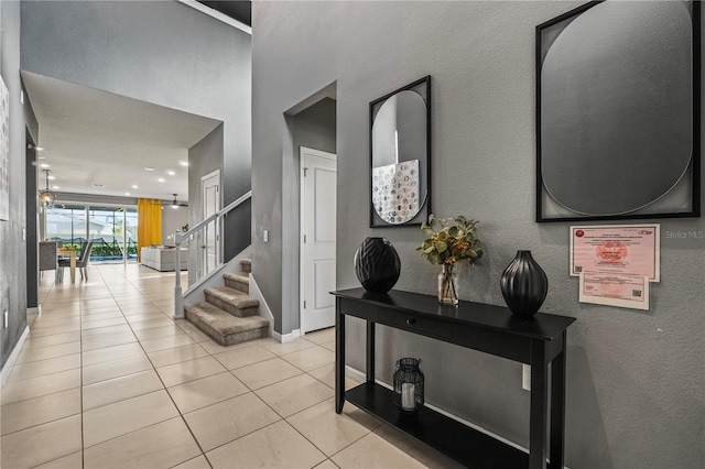 hallway with light tile patterned floors and a chandelier