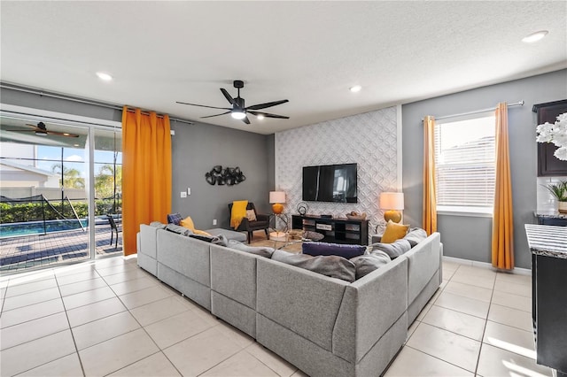 tiled living room with ceiling fan and a textured ceiling