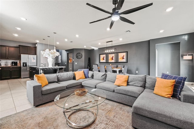 tiled living room with ceiling fan and sink