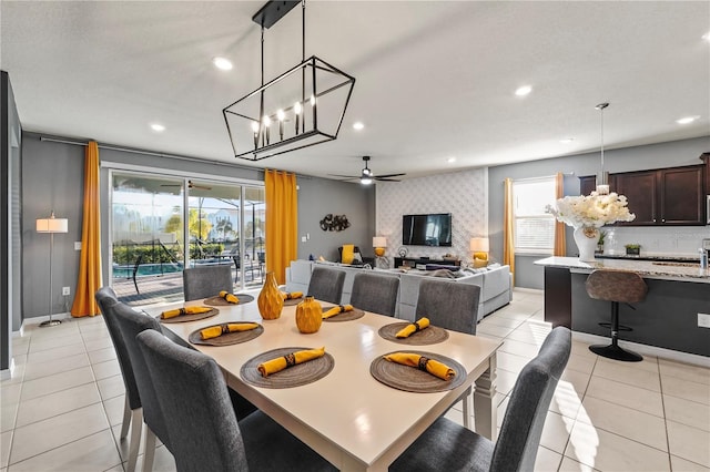 tiled dining space with ceiling fan with notable chandelier