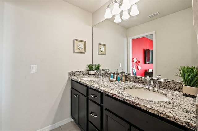 bathroom with vanity, a notable chandelier, and tile patterned floors