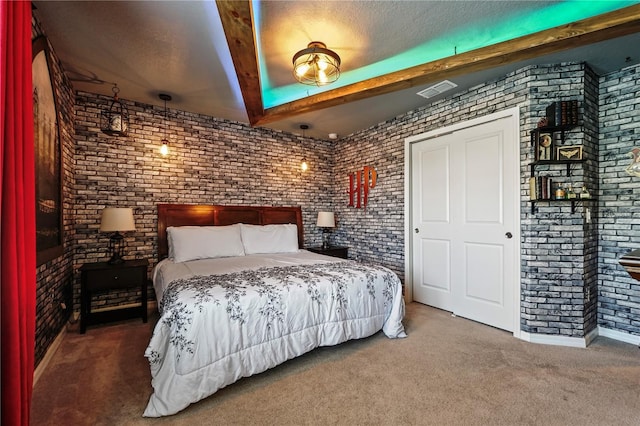 carpeted bedroom featuring beamed ceiling, brick wall, and a textured ceiling